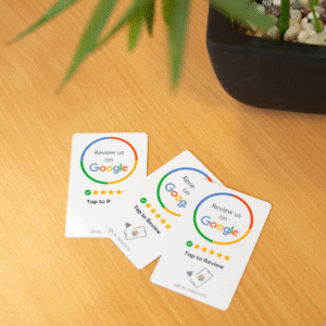 Three Tap to Review cards on a wooden desk, designed to help businesses collect more Google reviews quickly and easily.